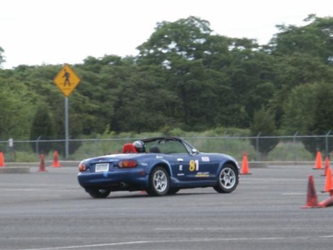 2001 Mercury Grand Marquis - Blue convertible sports car with racing number 81 on the side, driving on a paved course with orange cones.