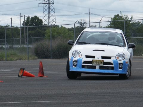 2001 Mercury Grand Marquis - A white Dodge Neon SRT-4 is seen on a track with blue tape applied to its front bumper and hood.