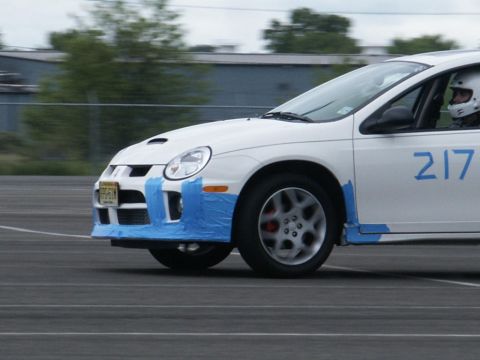2001 Mercury Grand Marquis - A white Dodge Neon, identified by racing number 217, is seen on a track with blue tape applied to its front bumper.