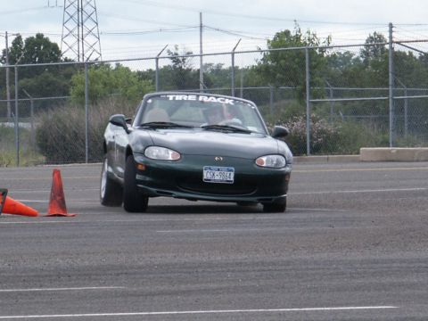 2001 Mercury Grand Marquis - A dark green convertible navigates a course marked by traffic cones on a cloudy day.