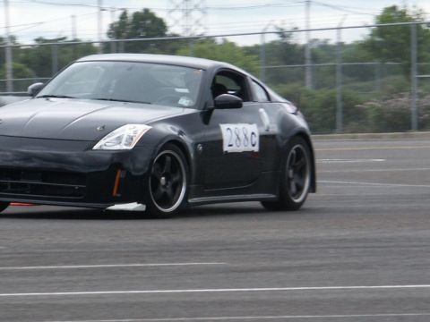 2001 Mercury Grand Marquis - Black Nissan 350Z with racing number 288c on door, seen on a track.