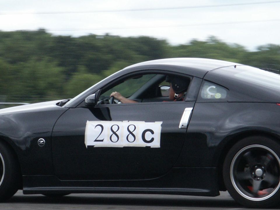 Black sports car with number 288c on the side, driver wearing a hat