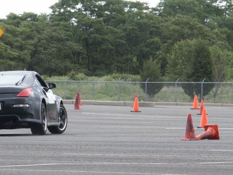 2001 Mercury Grand Marquis - A black sports coupe navigates a course marked by orange traffic cones on an asphalt track.