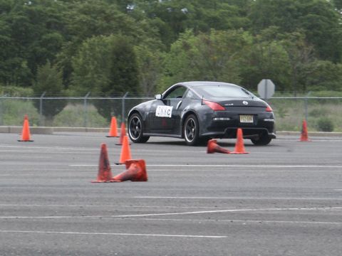 2001 Mercury Grand Marquis - A black Nissan 350Z is shown on an asphalt course, maneuvering around orange traffic cones.