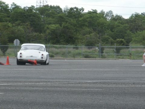 2001 Mercury Grand Marquis - A white vintage sports car navigates a course marked by orange cones on an asphalt surface.