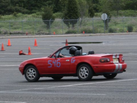 2001 Mercury Grand Marquis - A red convertible with racing stripes and the number 546 is driven on a track with orange cones.