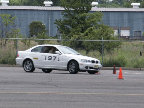 2001 Mercury Grand Marquis - A white coupe with racing numbers is seen on a track, navigating around orange cones.
