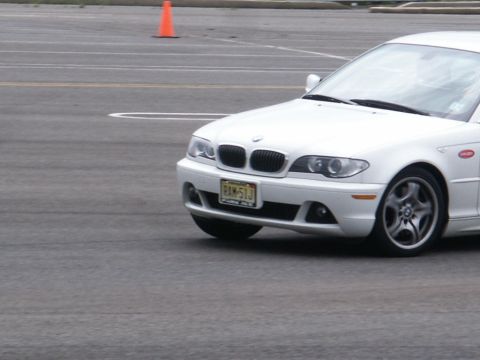 2001 Mercury Grand Marquis - A white BMW sedan is captured from the front, showing its distinctive grille and headlights on a paved surface.