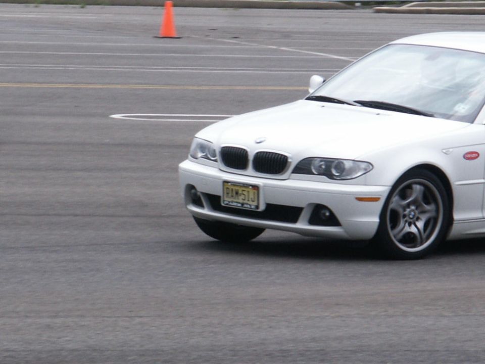 White BMW sedan with a New Jersey license plate, seen from the front