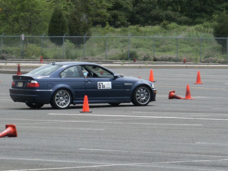 Blue coupe with racing number 61A on a track with orange cones