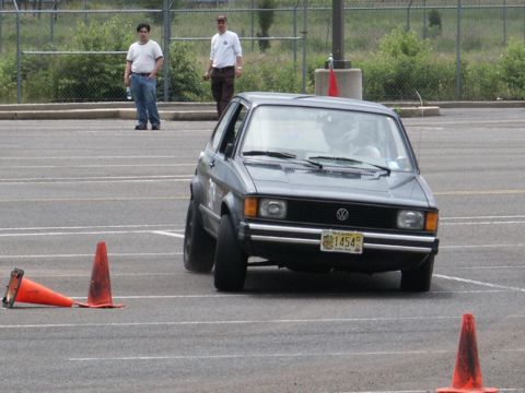 2001 Mercury Grand Marquis - A gray Volkswagen Golf GTI is shown on an autocross course, with two people watching in the background.