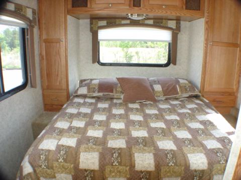 2005 Chevrolet C-6500/Kodiak - Interior view of a recreational vehicle's bedroom, a large bed and ample storage.
