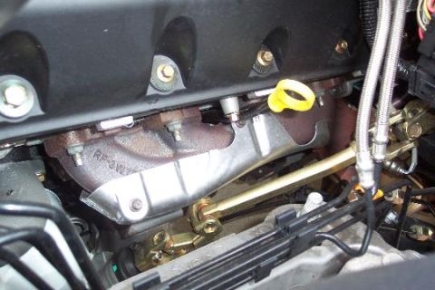 2003 Ford Crown Victoria - Close-up view of an engine's exhaust manifold and related components.