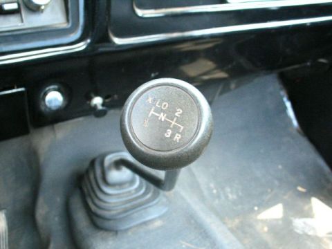 1979 Ford Bronco - The interior of a vehicle shows a manual transmission shifter with its gear pattern clearly visible.