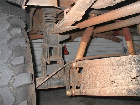 1979 Ford Bronco - The rear suspension of a 1979 Ford Bronco shows leaf springs and shocks, with a large tire visible.