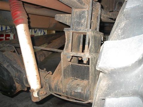 1979 Ford Bronco - Close-up view of the rear suspension components and a large tire on a vehicle.