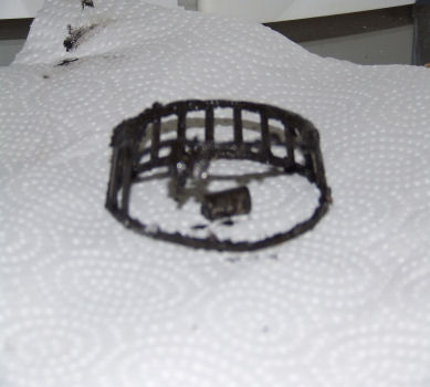 1988 Ford Bronco - This is a damaged wheel bearing cage and roller, likely from a vehicle's wheel assembly.