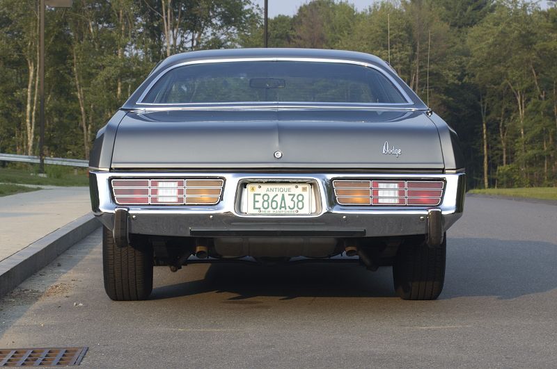 Rear of silver Dodge coupe with NH antique plate E86A38 on a tree-lined road