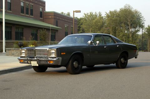 1978 Dodge Monaco - A dark sedan with a distinctive grille and chrome bumper is shown from a three-quarter front angle.