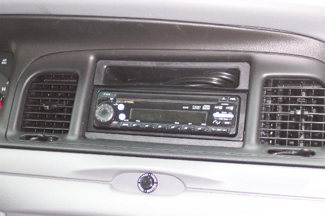 Aftermarket car stereo in gray dashboard flanked by air vents