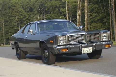 1978 Dodge Monaco - A 1978 Dodge Monaco sedan is shown in a front three-quarter view, parked on a paved surface with trees in the background.