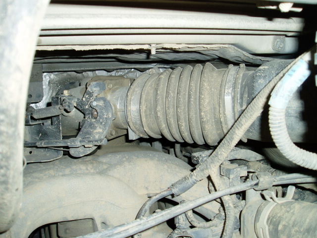 Dust-covered steering shaft with pleated rubber boot and U-joint under the hood
