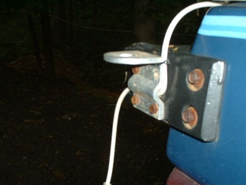 1985 Ford Bronco - Close-up of a steel bracket bolted to the rear corner of a blue truck body with large rusting bolt heads, holding a CB or radio antenna mou…