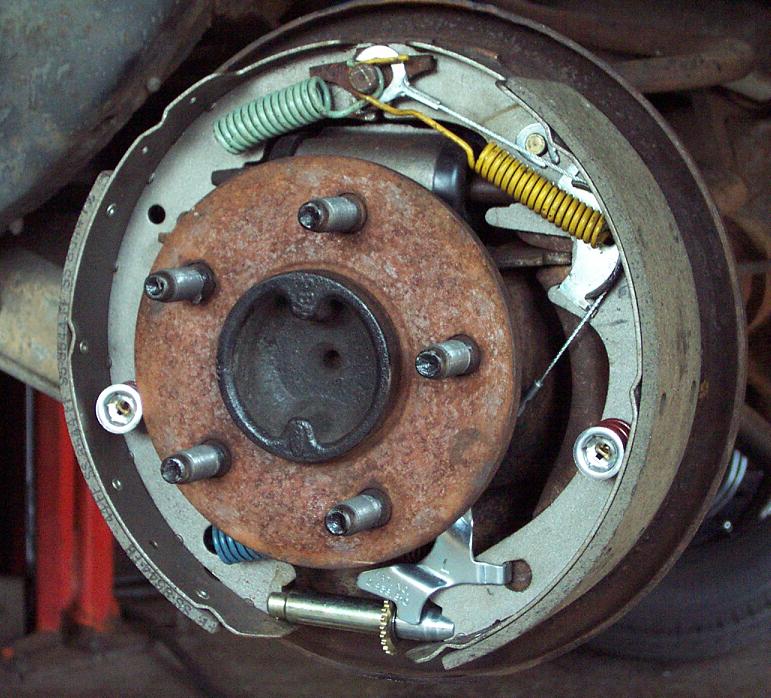 Rear drum brake assembly with rusty hub, five studs, brake shoes and springs