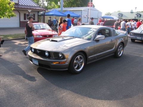 1989 Ford Mustang - A gray Ford Mustang with flame decals is displayed at an outdoor event.
