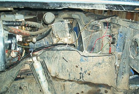 1986 Ford Bronco - Close-up view of the engine bay, showing various hoses, wiring, and a shock absorber. The registry claims this is a 1986 Ford Bronco, but t…