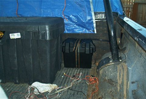 1986 Ford Bronco - Interior view of a truck bed containing storage containers and exposed wiring.