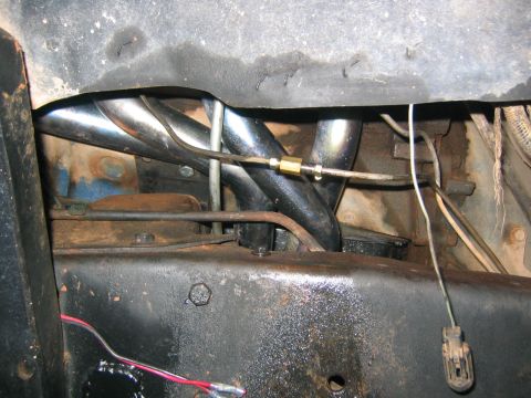 1979 Ford Bronco - Close-up view of exhaust headers and engine components, with visible wiring and fuel lines.