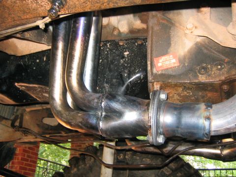 1979 Ford Bronco - Custom exhaust headers and piping installed on a vehicle's engine, with a visible part number sticker.