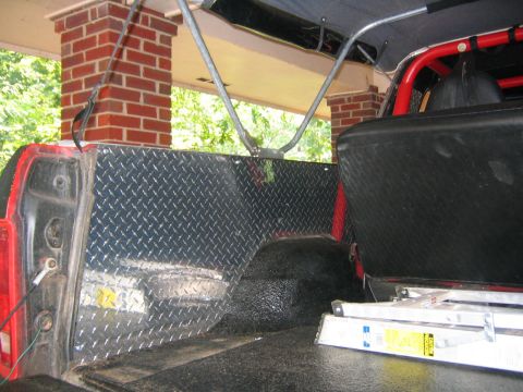 1979 Ford Bronco - Diamond plate lining installed in the rear cargo area of a vehicle, with a portion of the seat visible.