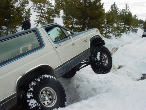 1986 Ford Bronco - This lifted Bronco navigates a challenging snowy terrain, its off-road capabilities.