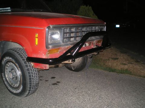 1985 Ford Bronco II - Front view of a red SUV with a black bull bar and aftermarket wheels.