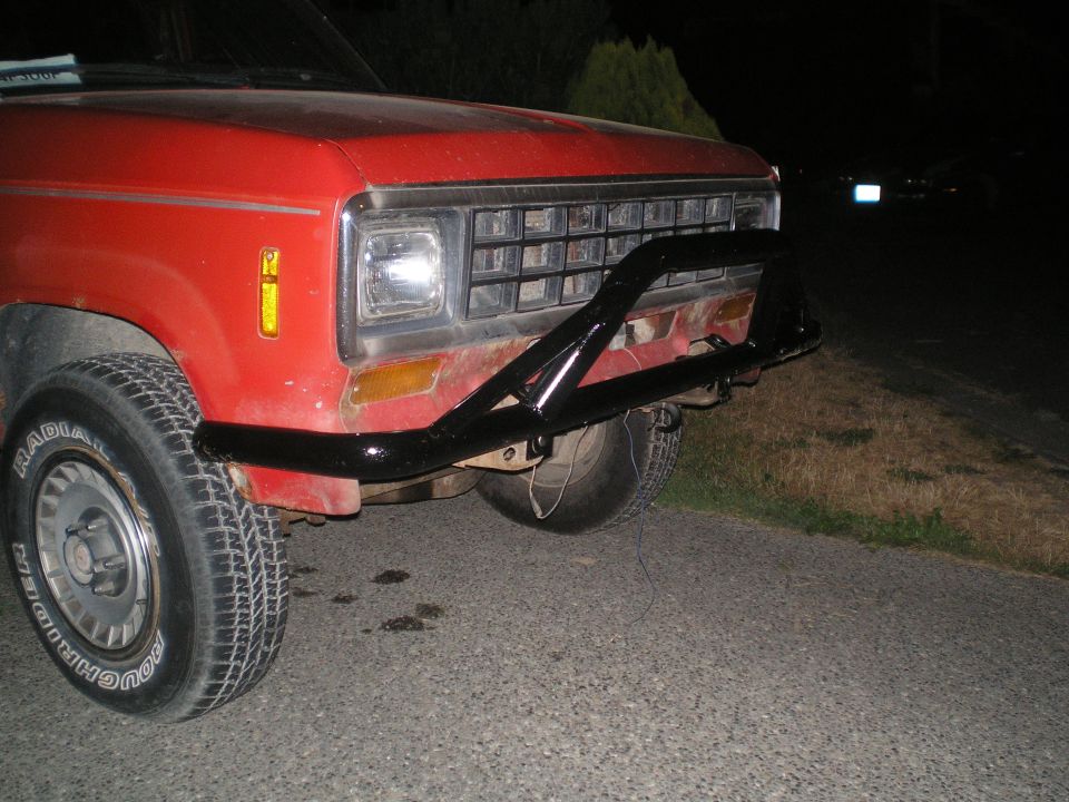 Red SUV front view, black bull bar, aftermarket wheels, grille visible