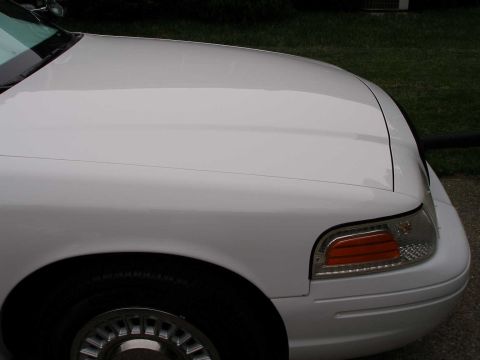 2001 Ford Crown Victoria - Close-up view of the front fender and hood of a white 2001 Ford Crown Victoria.