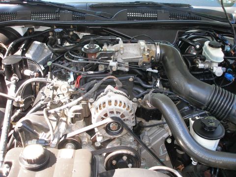 2001 Ford Crown Victoria - Close-up view of a vehicle's engine bay, showing various components like the alternator and intake manifold.