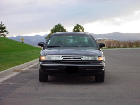 1998 Ford Crown Victoria - This sedan has a distinctive grille and headlight design, suggesting a mid-1990s model year.
