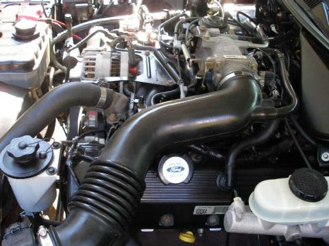 2001 Ford Crown Victoria - Close-up view of the engine bay in a 2001 Ford Crown Victoria, highlighting the V8 engine and associated parts.