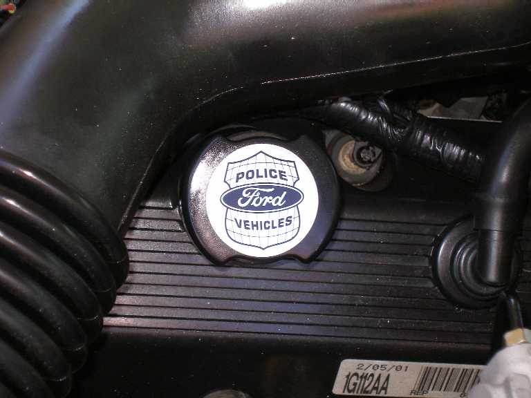 Close-up of a Ford Police Vehicles oil cap on an engine. Date 2/05/01 visible