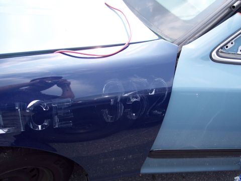 1991 Ford LTD Crown Victoria - Scratched numbers and 'POLICE' text are visible on the fender of a two-tone blue vehicle.
