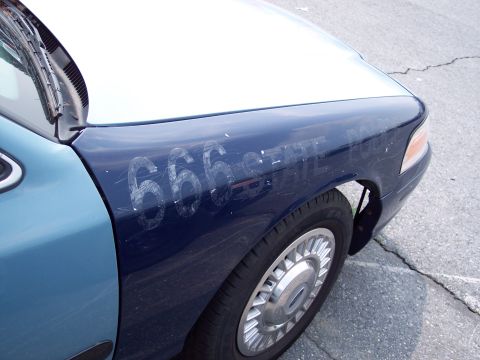 1991 Ford LTD Crown Victoria - A car fender with the numbers 666 and text "CTL" scratched into the paint.