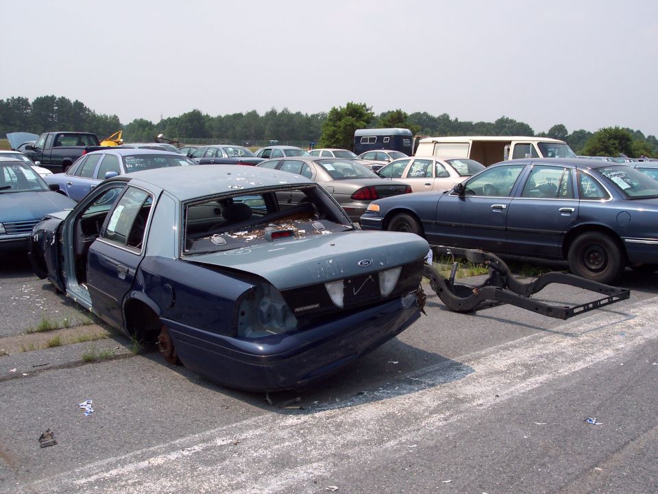 Rear view of wrecked 1991 Ford Crown Victoria LTD, missing doors and wheels