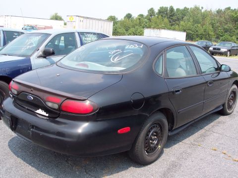 1991 Ford LTD Crown Victoria - A black sedan is parked in an outdoor lot with other vehicles visible.