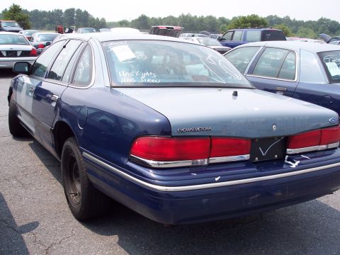 1991 Ford LTD Crown Victoria - Rear view of a blue and grey 1991 Ford Crown Victoria, showing the 'CROWN VICTORIA' badging and visible text on the rear window.