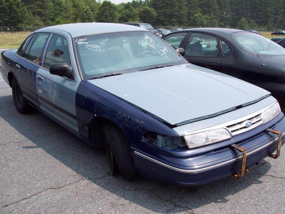 1991 Ford Crown Victoria LTD police car with "STATE POLICE" text on fender, missing headlight