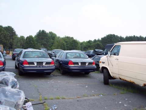 1991 Ford LTD Crown Victoria - Several Ford Crown Victorias are parked in an outdoor lot with a white van.