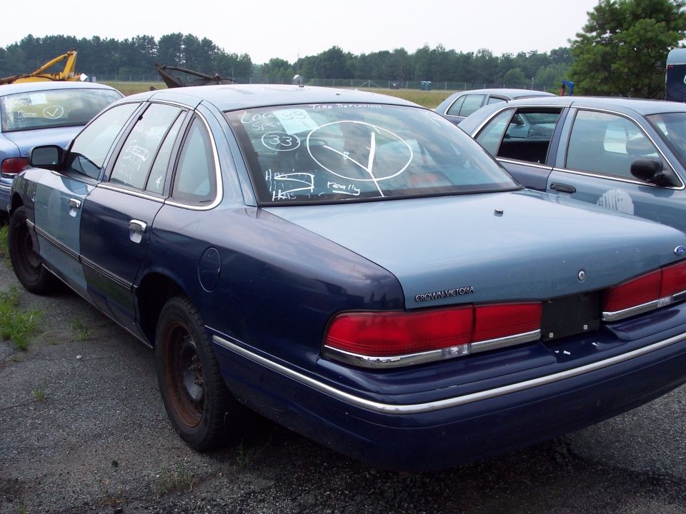 1991 Ford Crown Victoria LTD sedan, rear view, parked in lot with other vehicles